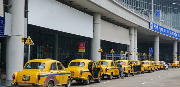 Kolkata, India - July 8, 2015: Yellow Ambassador taxi cars waiting passenger at arrival of International Kolkata airport in Kolkata, India. First Ambassador was produced in 1921.